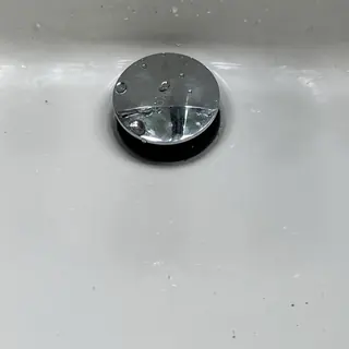 Bathroom sink Kohler pop-up drain assembly with water droplets