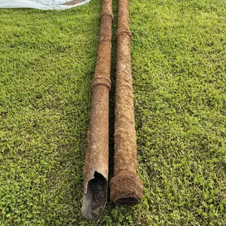 Cast iron sewer pipes rusted and damaged on grass