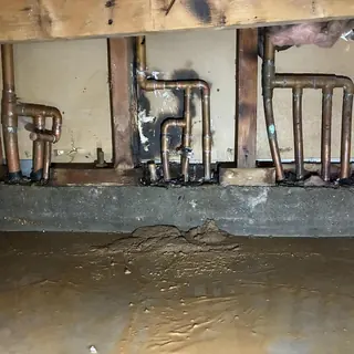 Copper plumbing pipes with burn and water damage in wall cavity