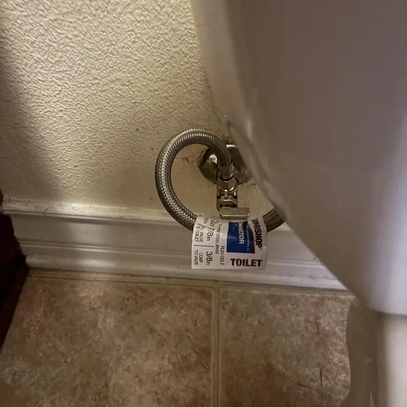 Quarter turn angle stop and supply line behind toilet