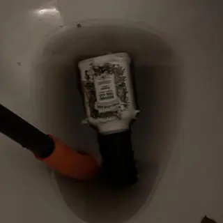 Toilet trap clogged by bottle with auger tool
