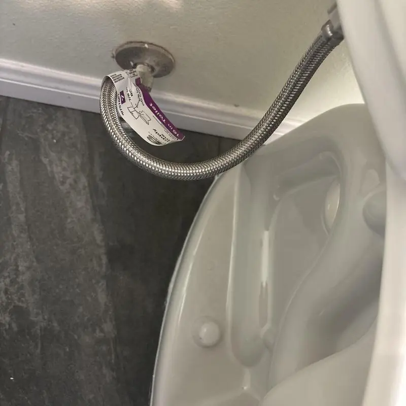 Elongated toilet supply line and angle stop installation