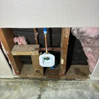 Ice-maker water line reroute in a wall cavity