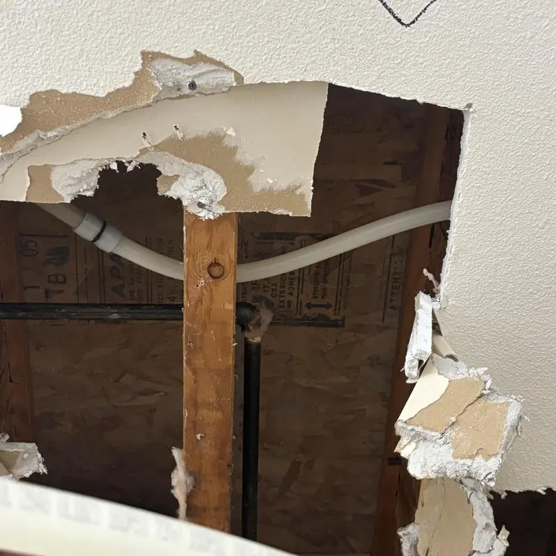 Cracked PEX water line exposed behind ceiling drywall in Wildomar