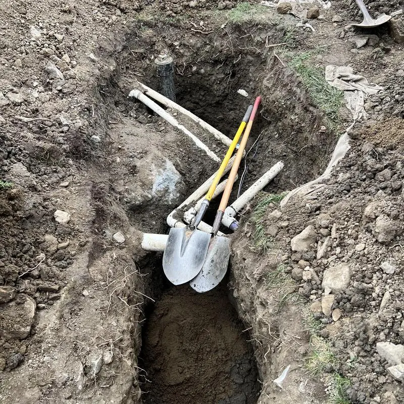 Main sewer line excavation with shovels and pipe repair